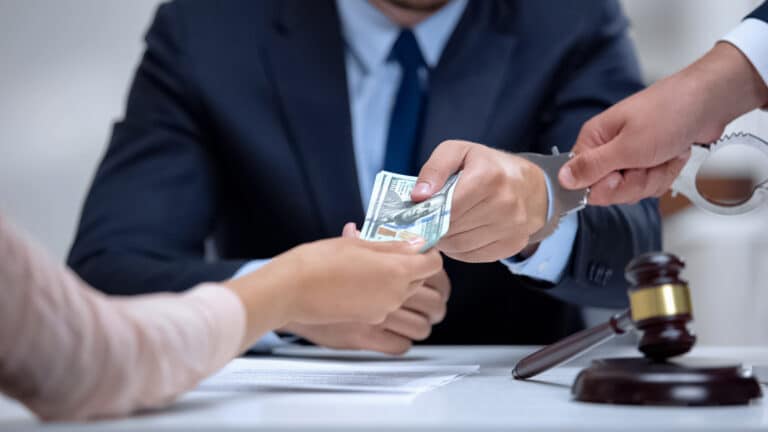 A man getting arrested while taking a bribe in a courtroom
